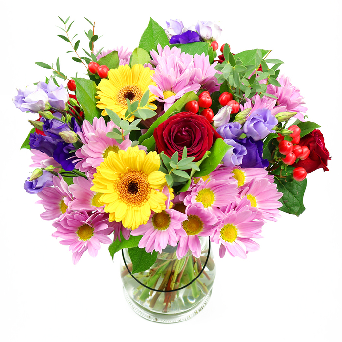 In this photograph, a luxurious mixed bouquet rises from a clear glass vase, framed by a clean white background that allows every hue and detail to stand out, as if displayed in a calm corner of a home off Elmers End Road. Deep red roses form the emotional core of the arrangement, their plush, layered petals unfolding in tight, romantic spirals that immediately draw attention. Just above and alongside them, two bright yellow gerbera daisies lift their open faces toward the viewer, their bold petals encircling dark, warm-toned centres that feel both joyful and grounding-like a burst of sunshine breaking through clouds over nearby Beckenham. Flowing outwards, soft pink and lilac-toned daisies or chrysanthemums expand the bouquet's shape, each flower formed from many slim petals radiating around tiny yellow centres, building a cushion of gentle colour and airy texture. Threaded between these softer forms are rich purple and lavender lisianthus, their slightly ruffled, bell-shaped blooms adding a cooler note and creating pleasing depth as they rise and dip through the design. Here and there, bright red hypericum berries appear in neat clusters, glossy and rounded, giving the arrangement a lively, tactile contrast among the petals. A tapestry of green foliage-darker broad leaves paired with lighter, more delicate sprigs-wraps around and supports the flowers, suggesting freshness and the skilled hand of a local florist. The glass vase reveals straight, evenly cut stems resting in clear water, a quiet reminder of the care taken in preparation. The bouquet feels warm, uplifting, and versatile, well suited for celebrating a birthday near Elmers End tram stop, saying thank you to neighbours, or adding a vibrant focal point to a dining table during a family gathering.